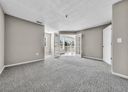 an empty living room and hallway with doors to a patio at Trophy Club at Bellgrade, Midlothian, VA, 23113
