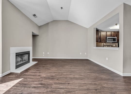 an empty living room with a fireplace and a kitchen at Trophy Club at Bellgrade, Midlothian, VA, 23113