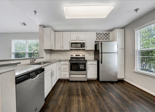 a kitchen with white cabinets and stainless steel appliances at Trophy Club at Bellgrade, Midlothian, VA, 23113