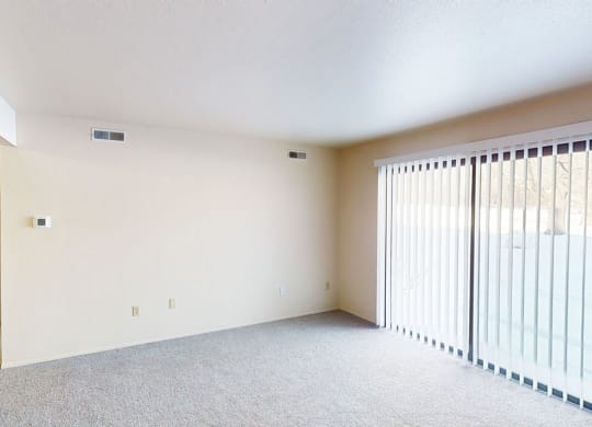 a living room with a sliding door to a patio at Walnut Trail Apartments in Portage, MI 49002