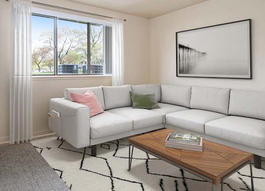 A garden style living room with a grey couch, a wooden coffee table, and a large window with curtains at Walnut Trail Apartments, Portage, MI, 49002