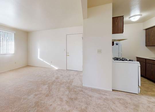 A spacious living and dining room with a large window  at Walnut Trail Apartments, Michigan