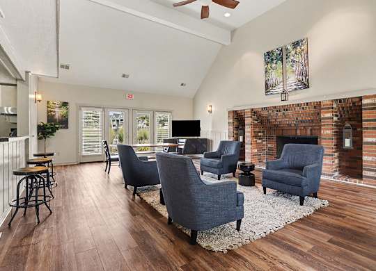 A community room with a fireplace and a painting on the wall at Walnut Trail Apartments, Michigan