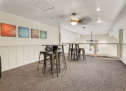 A community room loft area with a grey carpet and a ceiling fan at Walnut Trail Apartments, Michigan