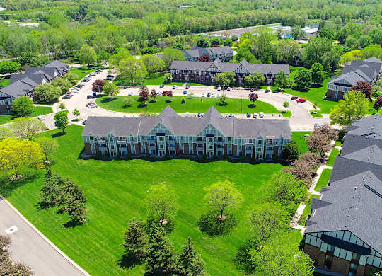A large building with a green lawn in front of it at Walnut Trail Apartments, Michigan