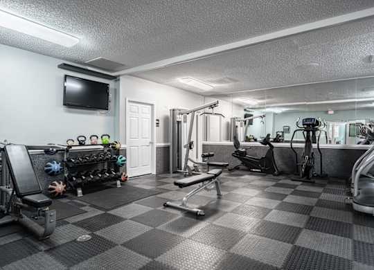A well-equipped gym with a variety of exercise machines and weights at WaterFront Apartments, Virginia Beach, 23453