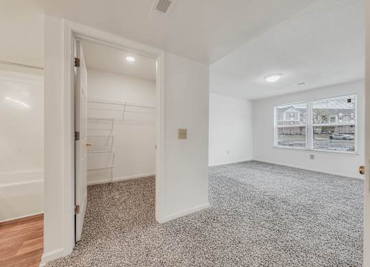 A room with a carpeted floor and a doorway leading to another room at WaterFront Apartments, Virginia Beach, 23453
