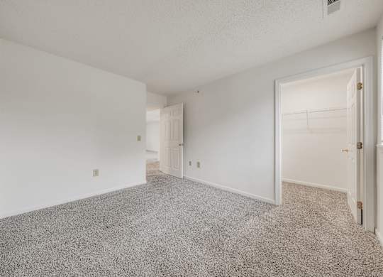 A sparsely furnished room with a carpeted floor and white walls at WaterFront Apartments, Virginia Beach, 23453