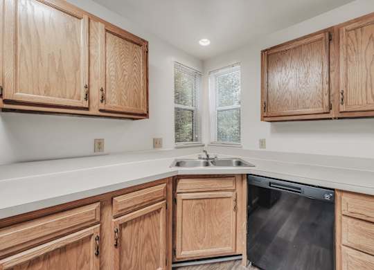 A kitchen with wooden cabinets and a dishwasher at WaterFront Apartments, Virginia Beach, 23453
