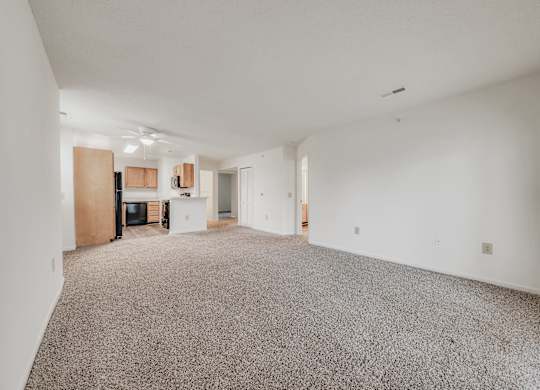 A spacious room with a grey carpet and white walls at WaterFront Apartments, Virginia Beach, 23453