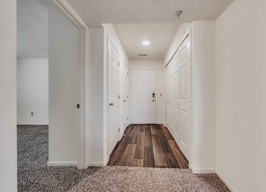 A long hallway with white walls and wood floors at WaterFront Apartments, Virginia Beach, 23453