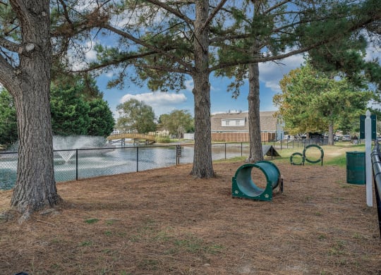 a pet-park with a lake and trees next to it at WaterFront Apartments, Virginia Beach