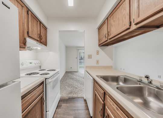 A kitchen with white appliances and wooden cabinets at WaterFront Apartments, Virginia Beach, 23453