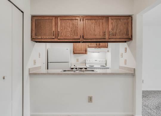 A kitchen with wooden cabinets and a stainless steel stove top at WaterFront Apartments, Virginia Beach, 23453