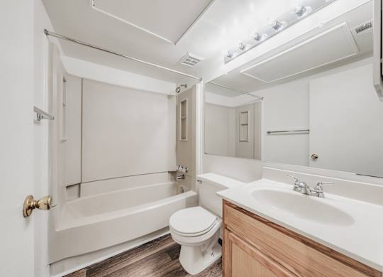A white bathroom with a toilet, sink, and bathtub at WaterFront Apartments, Virginia Beach, 23453