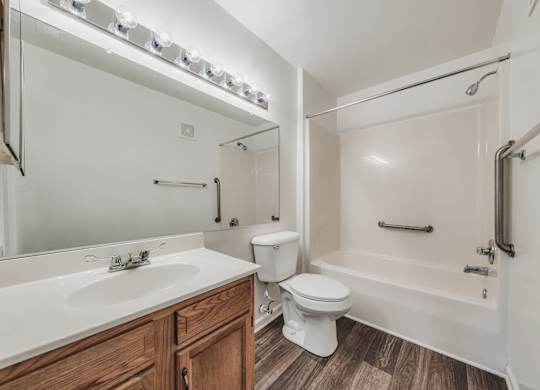 A white bathroom with a toilet, sink, and bathtub at WaterFront Apartments, Virginia Beach, 23453