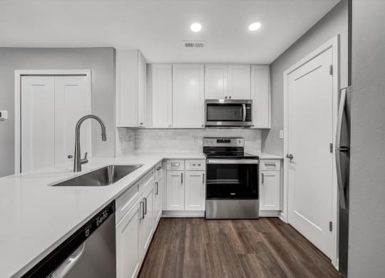Kitchen with white cabinets and stainless steel appliances at WaterFront Apartments, Virginia, 23453