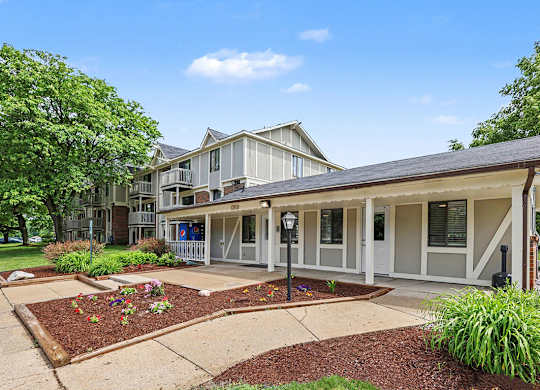 A leasing office with a grey roof with landscaping in front at Waverly Park Apartments, Lansing