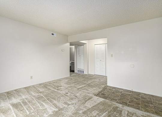 A living and dining room with a carpeted floor at West Wind Apartments in Fort Wayne, IN