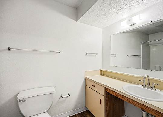 A toilet with a sink and a wooden counter  at West Hampton Park Apartment Homes, Nebraska, 68022