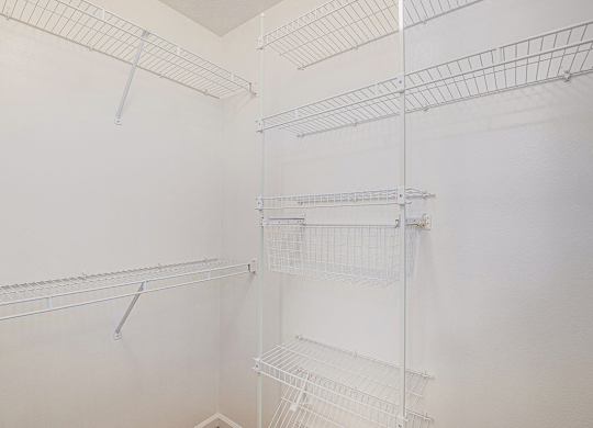 A walk-in closet with wardrobe organizers at West Hampton Park Apartments in Elkhorn, NE 68022