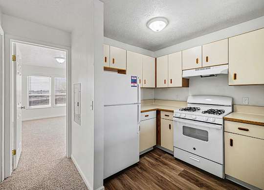 A kitchen with white appliances and hard-surface flooring  at West Hampton Park Apartment Homes, Nebraska, 68022