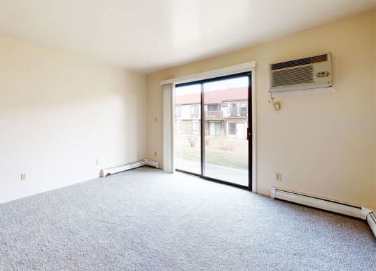 living room with a glass door to a patio  at Wood Creek Apartments, Kenosha