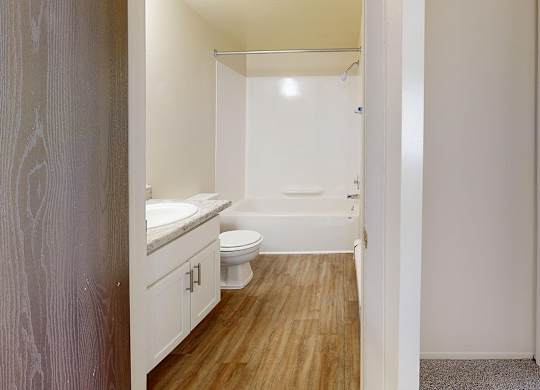 A bathroom with a toilet, sink, and bathtub at Wood Creek Apartments, Kenosha, WI, 53144