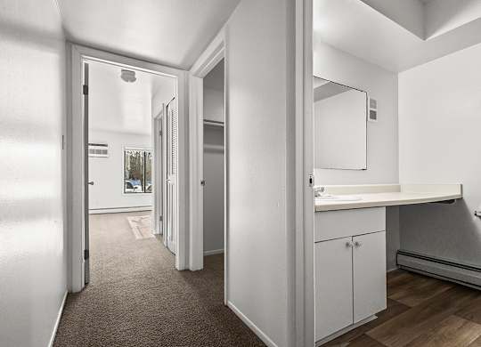 A bathroom with a sink, mirror, and toilet at Wood Creek Apartments, Kenosha