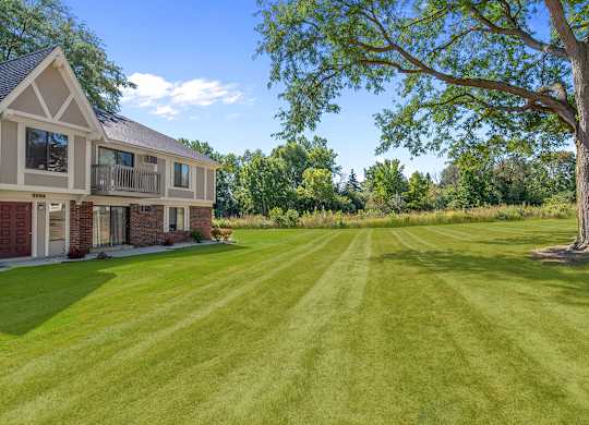 A large apartment building with a green lawn at Wood Creek Apartments, Wisconsin