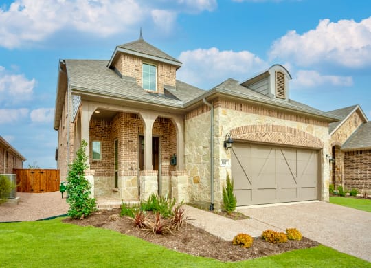 a home with a stone facade and a gray garage door