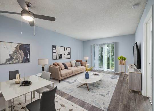 a living and dining room with a couch table and chairs and a tv on the wall