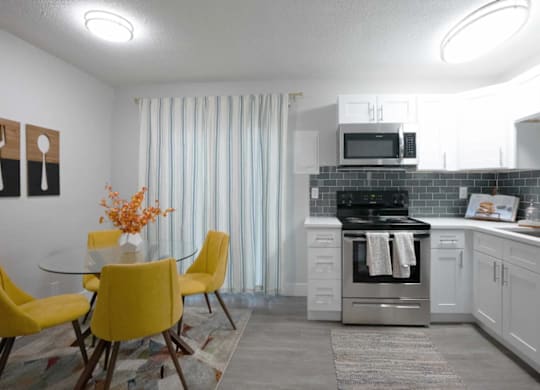 A kitchen with a yellow table and chairs.