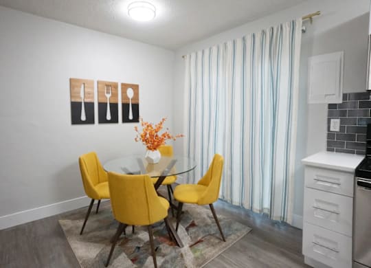 A kitchen with a table and chairs.