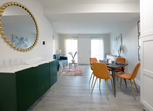A dining room with a table and chairs.