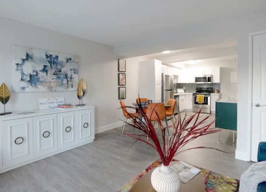 A white cabinet with a sign that says "Welcome" is in a room with a blue and white painting on the wall.