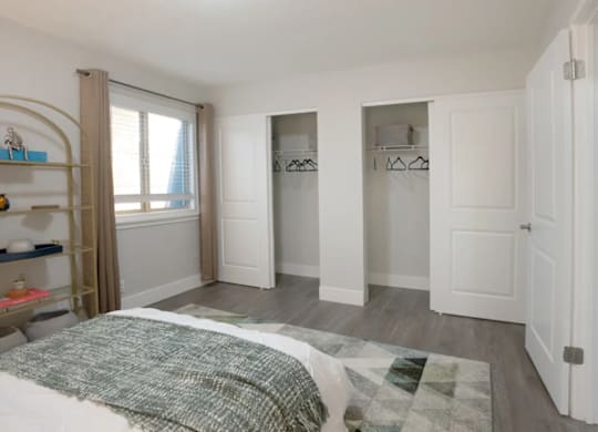 A bedroom with a bed, a wardrobe, and a shelf.