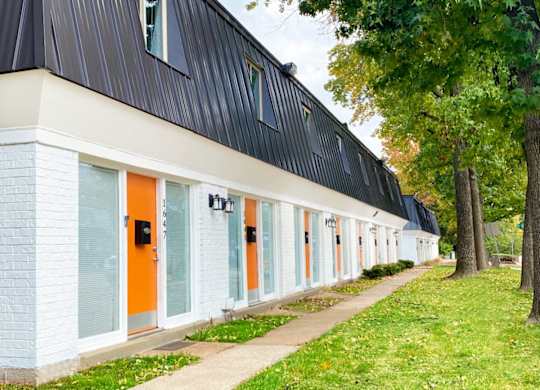 A long row of houses with orange doors.