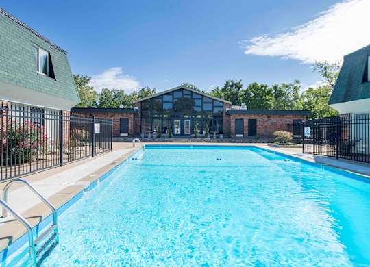 A large outdoor swimming pool surrounded by a black fence.