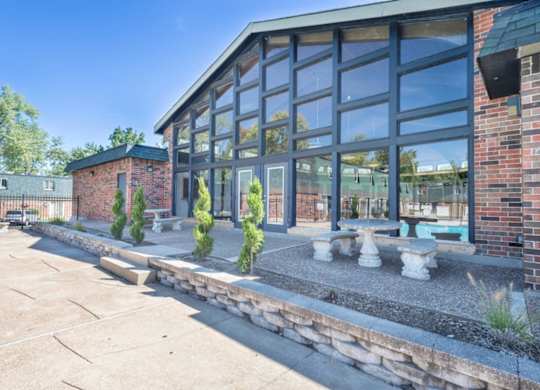 A modern building with a glass facade and a brick wall.
