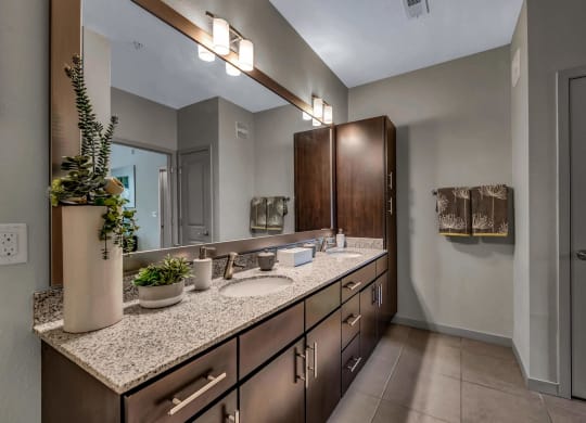 Bathroom with granite counter tops and a large mirror at Pearce at Pavilion Luxury Apartments, Florida, 33578