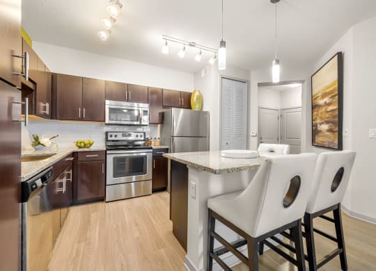 our spacious kitchen and dining room are equipped with stainless steel appliances and granite countertops at Pearce at Pavilion Luxury Apartments, Riverview, 33578
