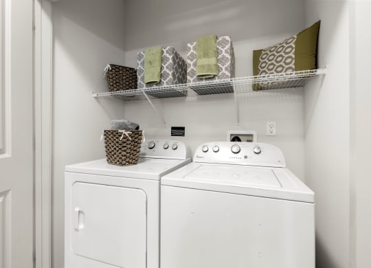 a white washer and dryer in a laundry room with a shelf above it