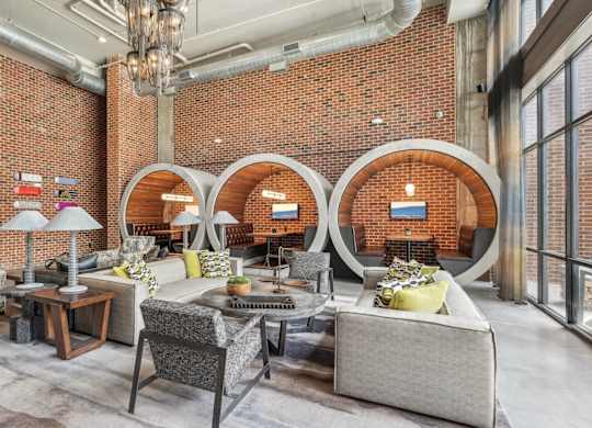 Resident clubhouse with many seating areas with couches, work booths, and chairs
