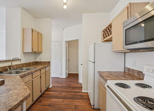 A kitchen with white appliances and wooden cabinets