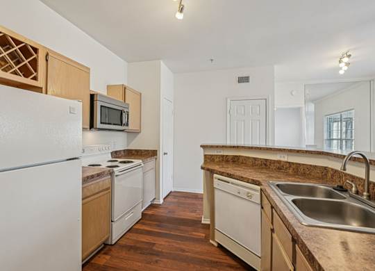 A kitchen with white appliances and wooden cabinets.