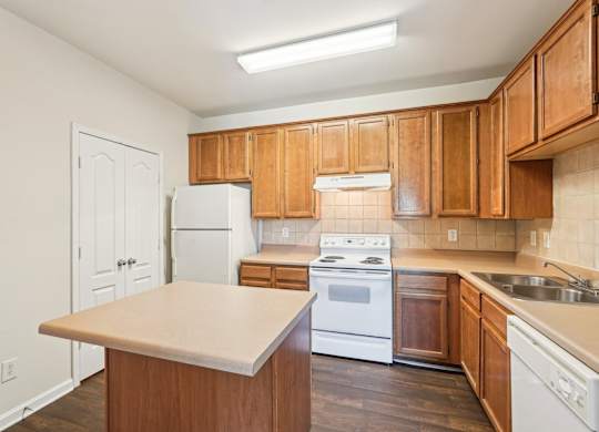 A kitchen with wooden cabinets and white appliances.