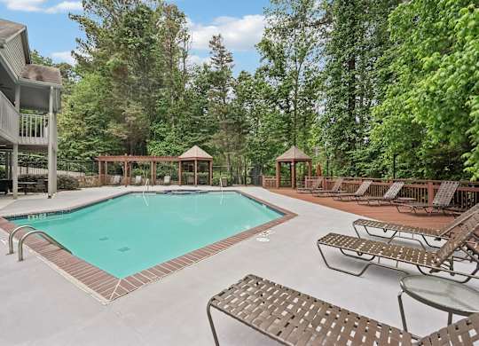 A pool with lounge chairs and tables