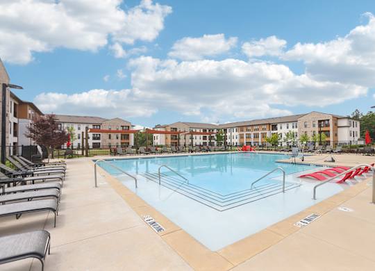 A large swimming pool with many lounge seats and areas
