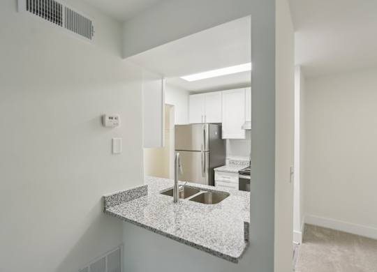 A kitchen with a granite countertop and stainless steel appliances.